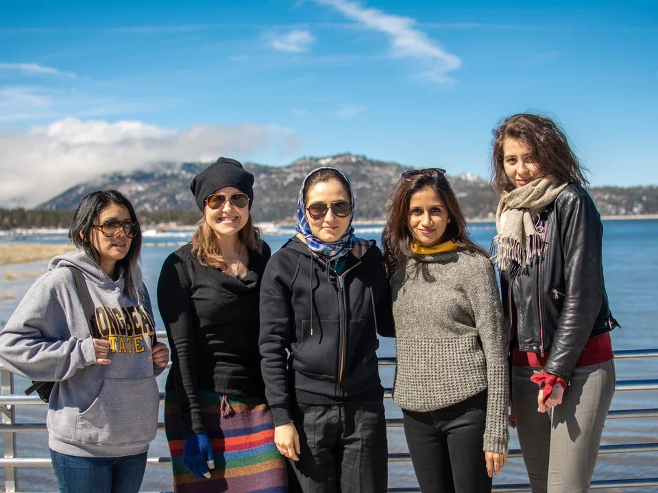 Five women from Butte Lab standing in front of lake wearing warm sweaters. We will someday get a photo of Chanti Mar 2019.
